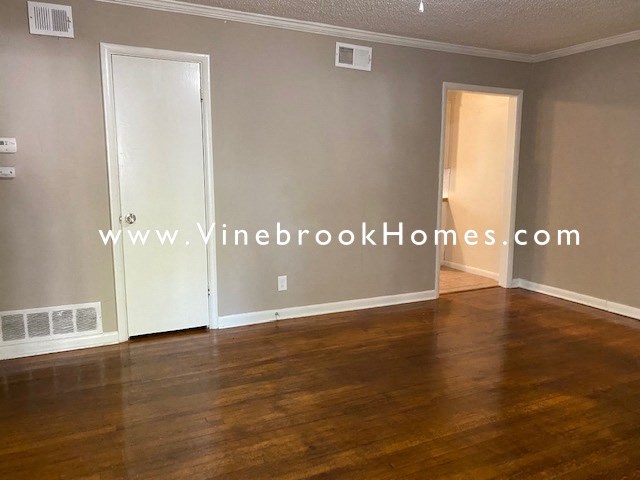 a living room with wood floors and grey walls and white doors
