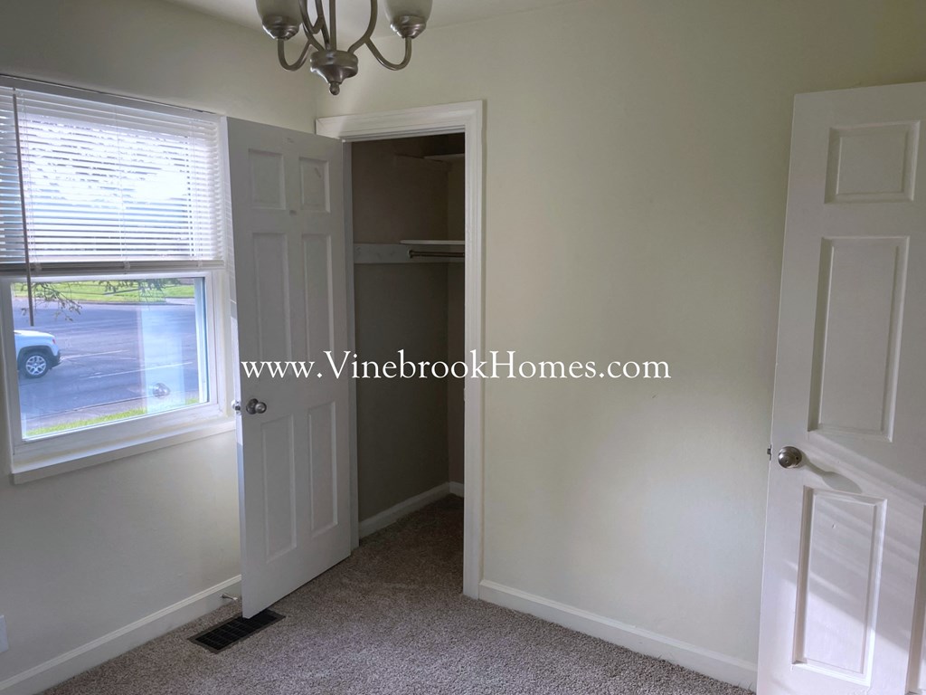 a closet in a small room with a window and a door