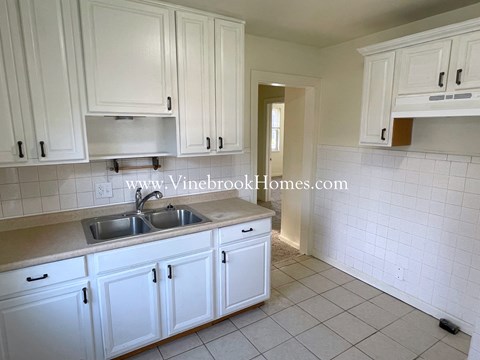 a kitchen with a sink and white cabinets