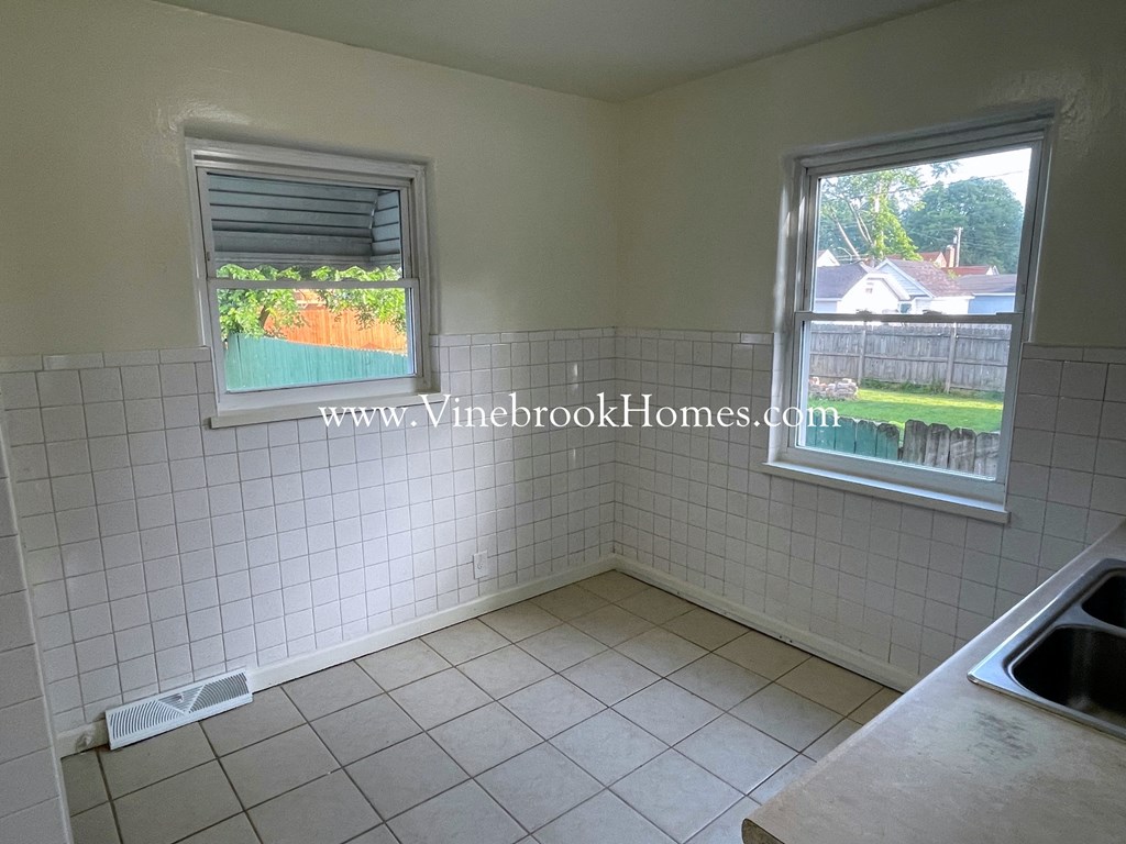 a small bathroom with a tiled wall and a window