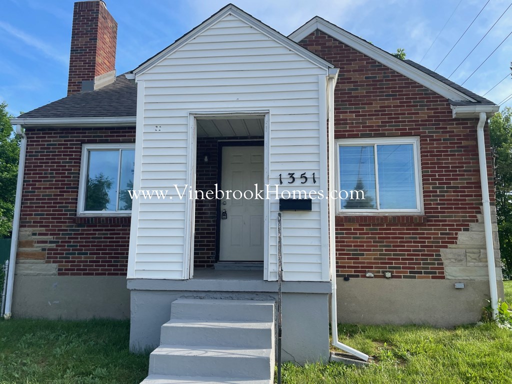 the front of a brick house with a white door