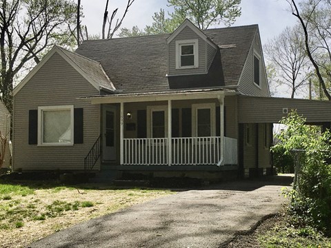 the front of the house with a covered porch