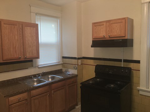 A kitchen with wooden cabinets and a black stove top oven.
