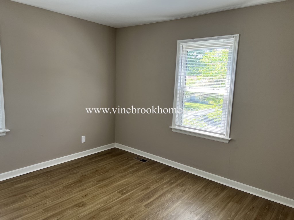 a small room with a window and wooden floors