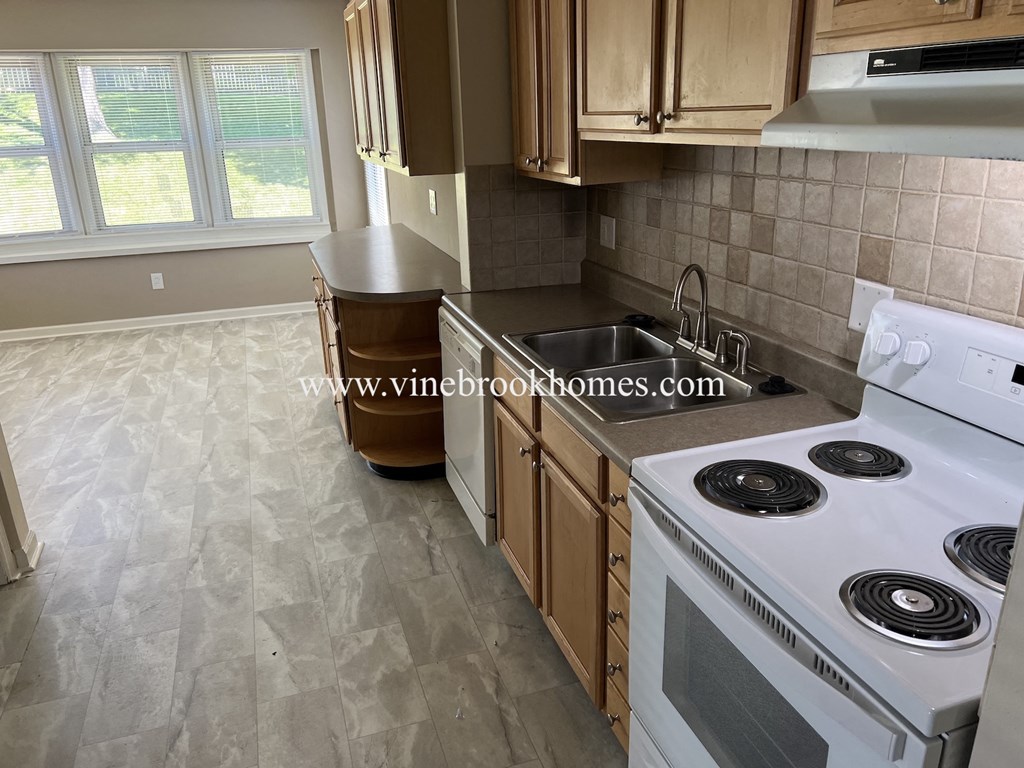 a kitchen with white appliances and wooden cabinets
