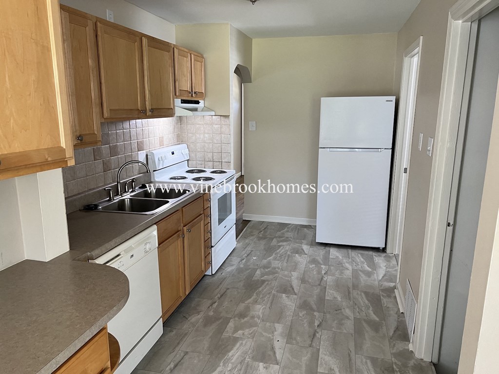 a small kitchen with white appliances and wooden cabinets