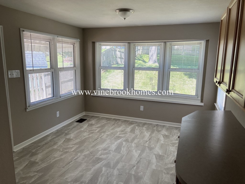 a small dining room with windows and a wooden floor