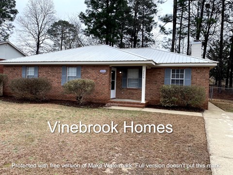a small brick house with a front yard and the words vine brook homes