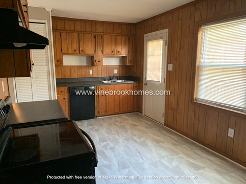 A kitchen with wooden cabinets and a black stove top oven.