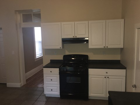 a kitchen with black appliances and white cabinets