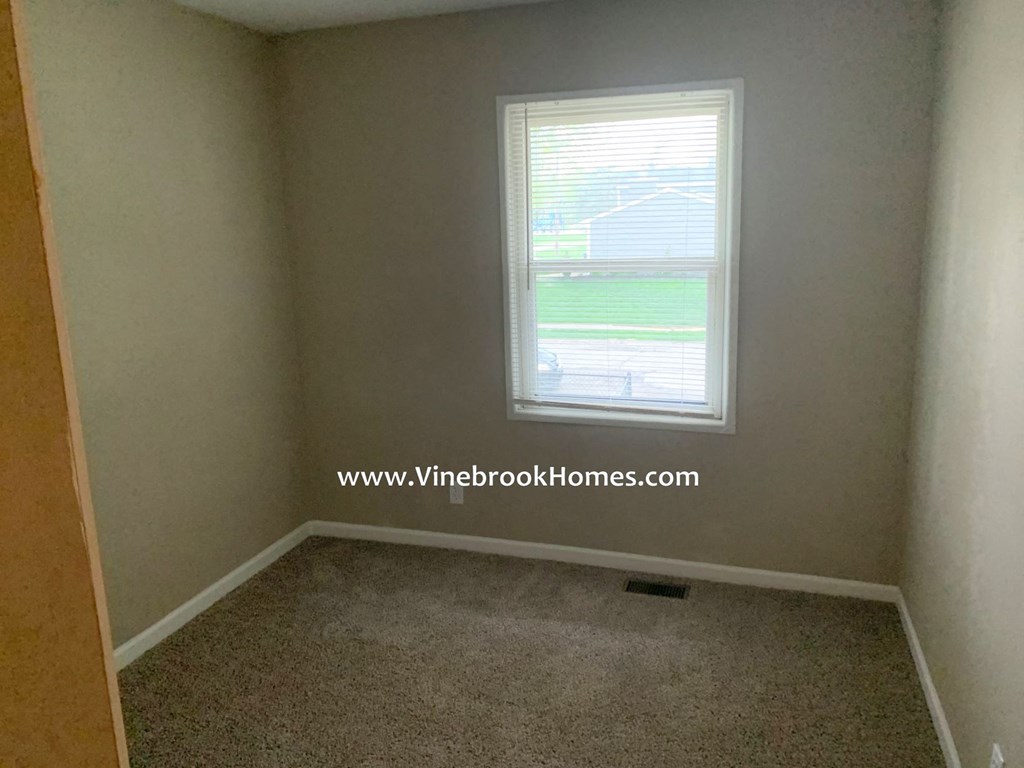 a small room with a window and a carpet