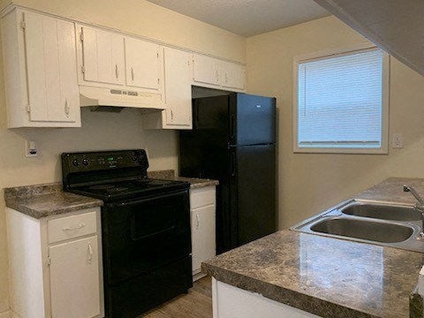 a kitchen with a stove refrigerator and sink