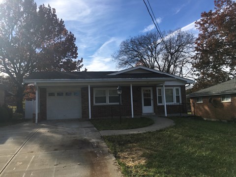 a brick house with a driveway and a garage door
