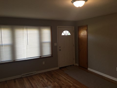 an empty living room with a window and a door
