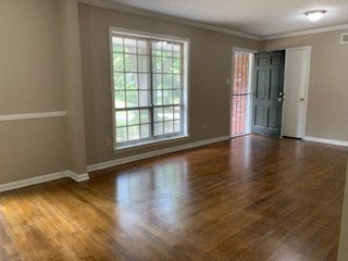 an empty living room with a hard wood floor