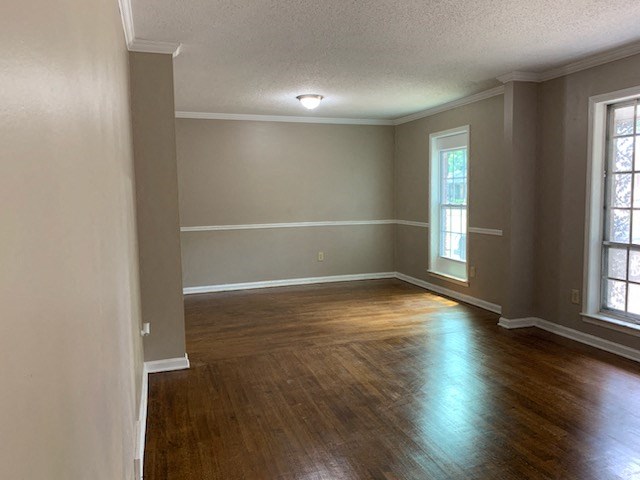 an empty living room with wood floors and a window