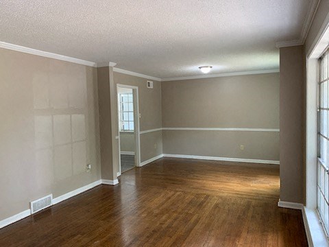 an empty living room with a hard wood floor and