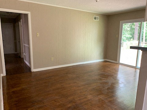 an empty living room with a wood floor and a door