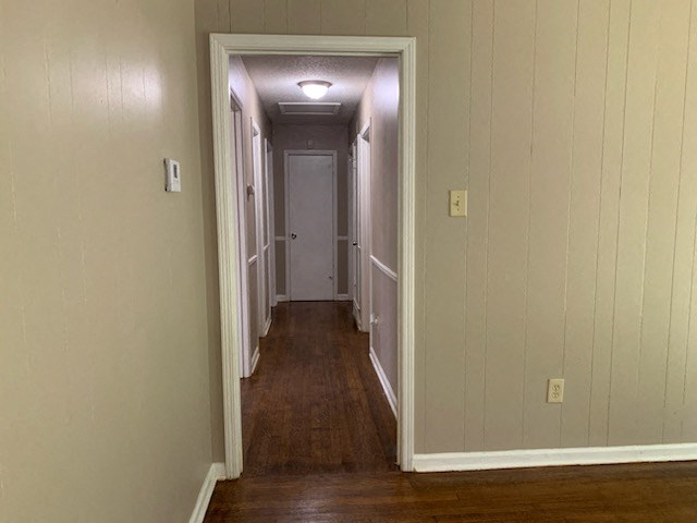 a hallway with a wooden floor and a white door