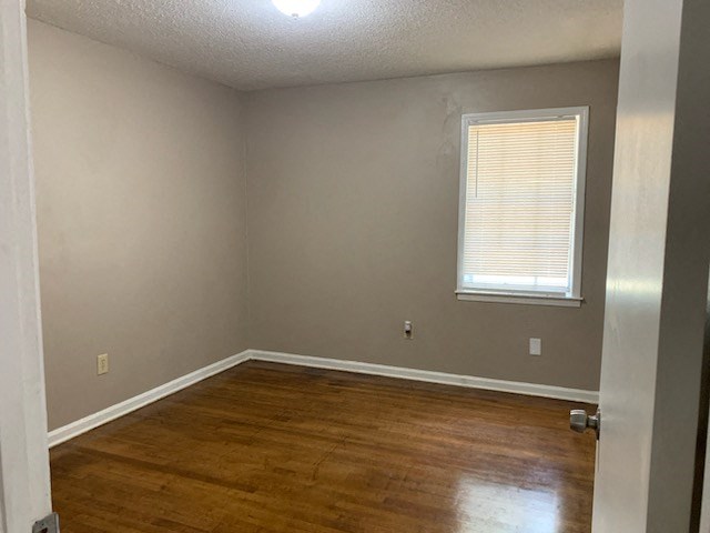 a empty room with a wooden floor and a window