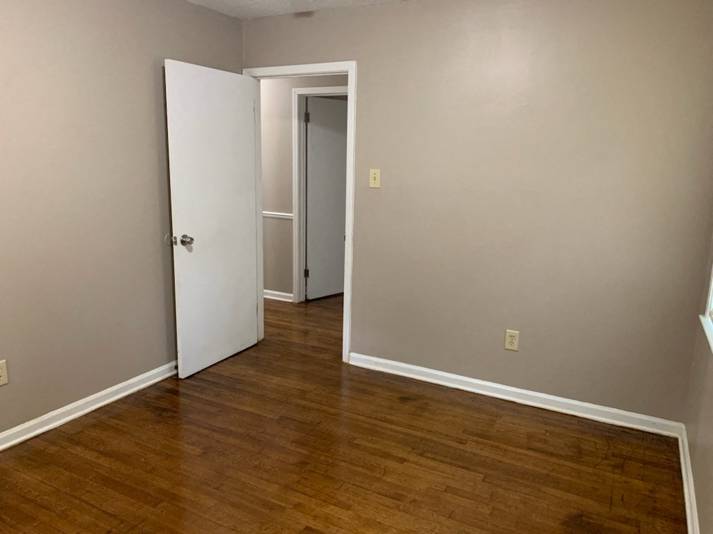 a room with a hard wood floor and a white door