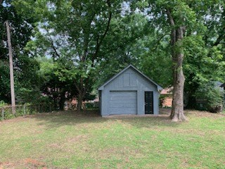 a shed in the middle of a field with trees