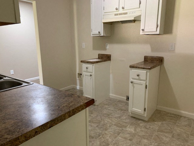 a kitchen with white cabinets and a counter top