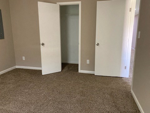 an empty room with three doors and a carpeted floor