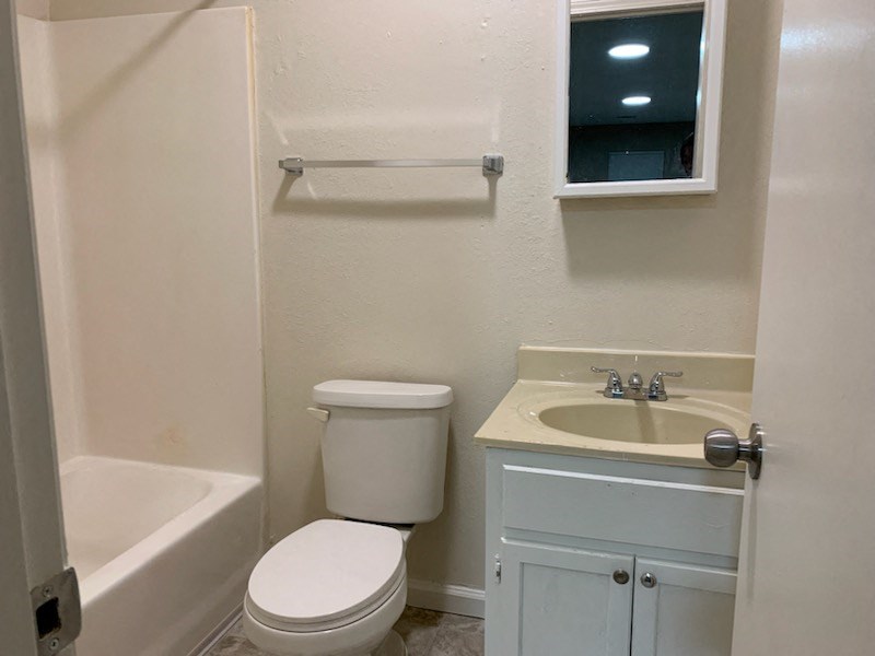 a bathroom with a toilet and a sink and a bath tub