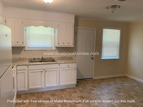 A kitchen with a sink and a refrigerator.