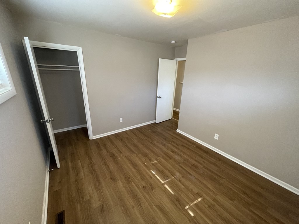 a empty room with wooden floors and a closet