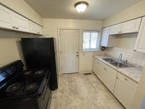 a kitchen with black appliances and white cabinets