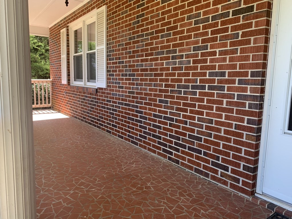 a brick house with a porch and a brick wall