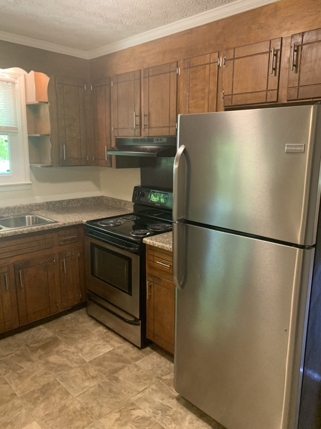 a kitchen with stainless steel appliances and wooden cabinets