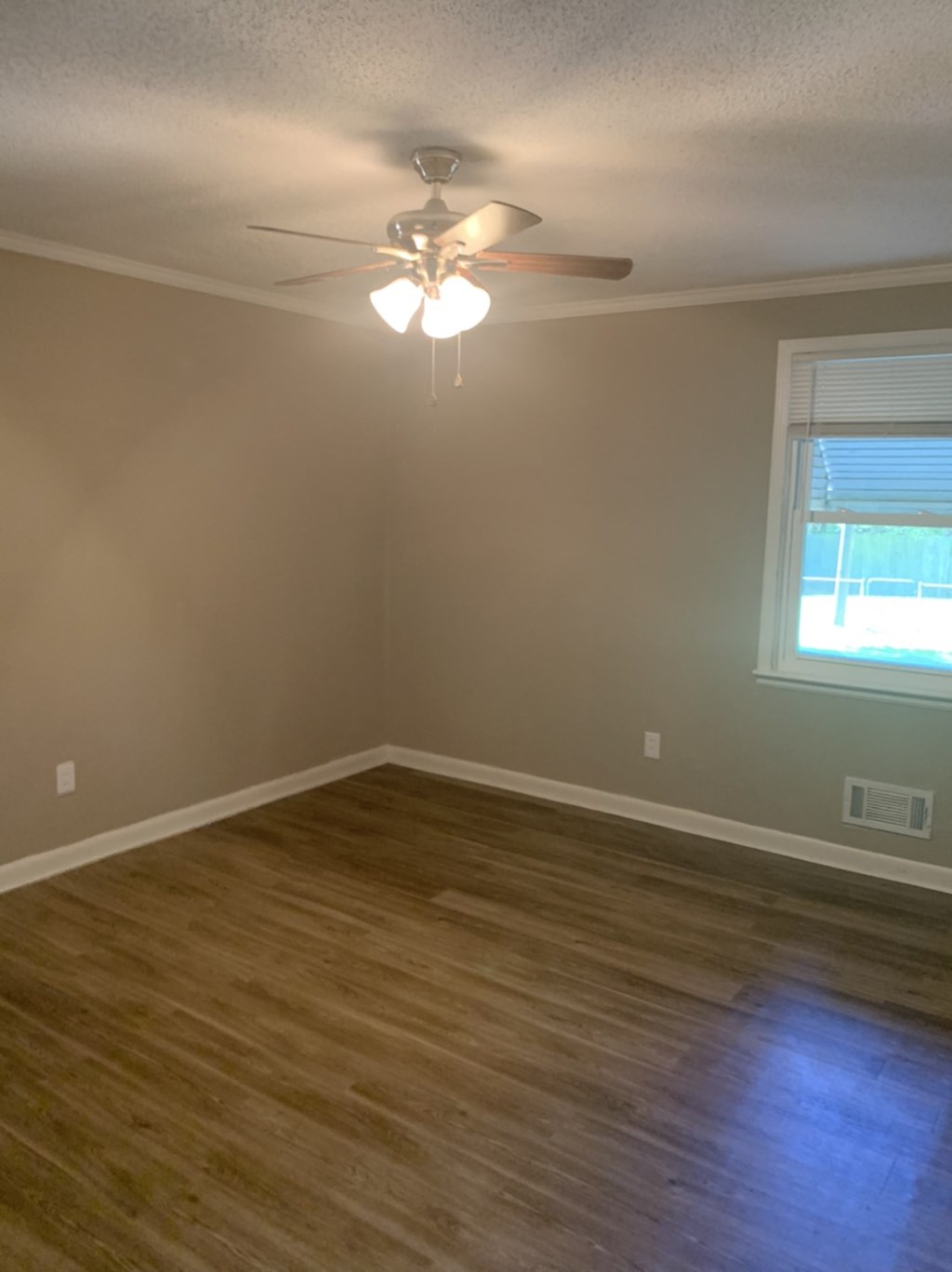 an empty room with a ceiling fan and a window