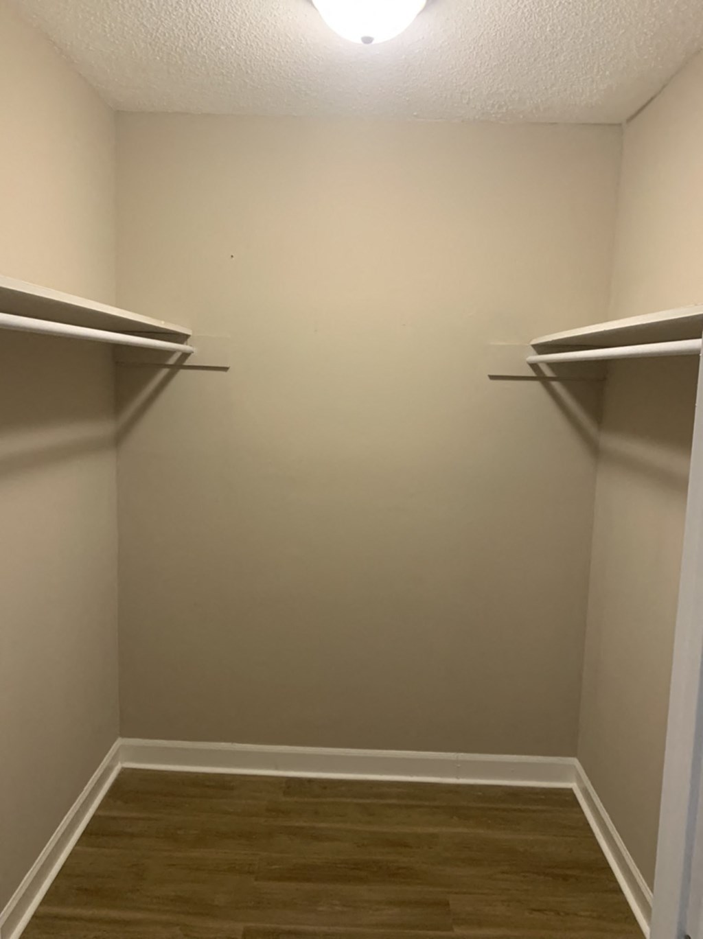 a walk in closet with two empty shelves