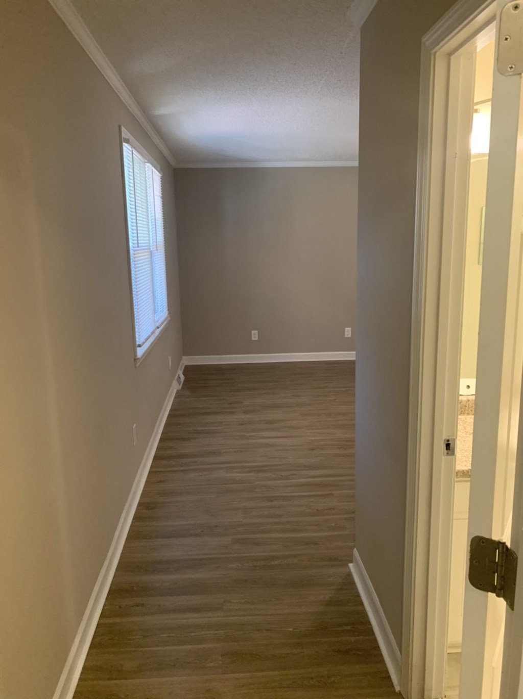 a hallway with wood floors and a window
