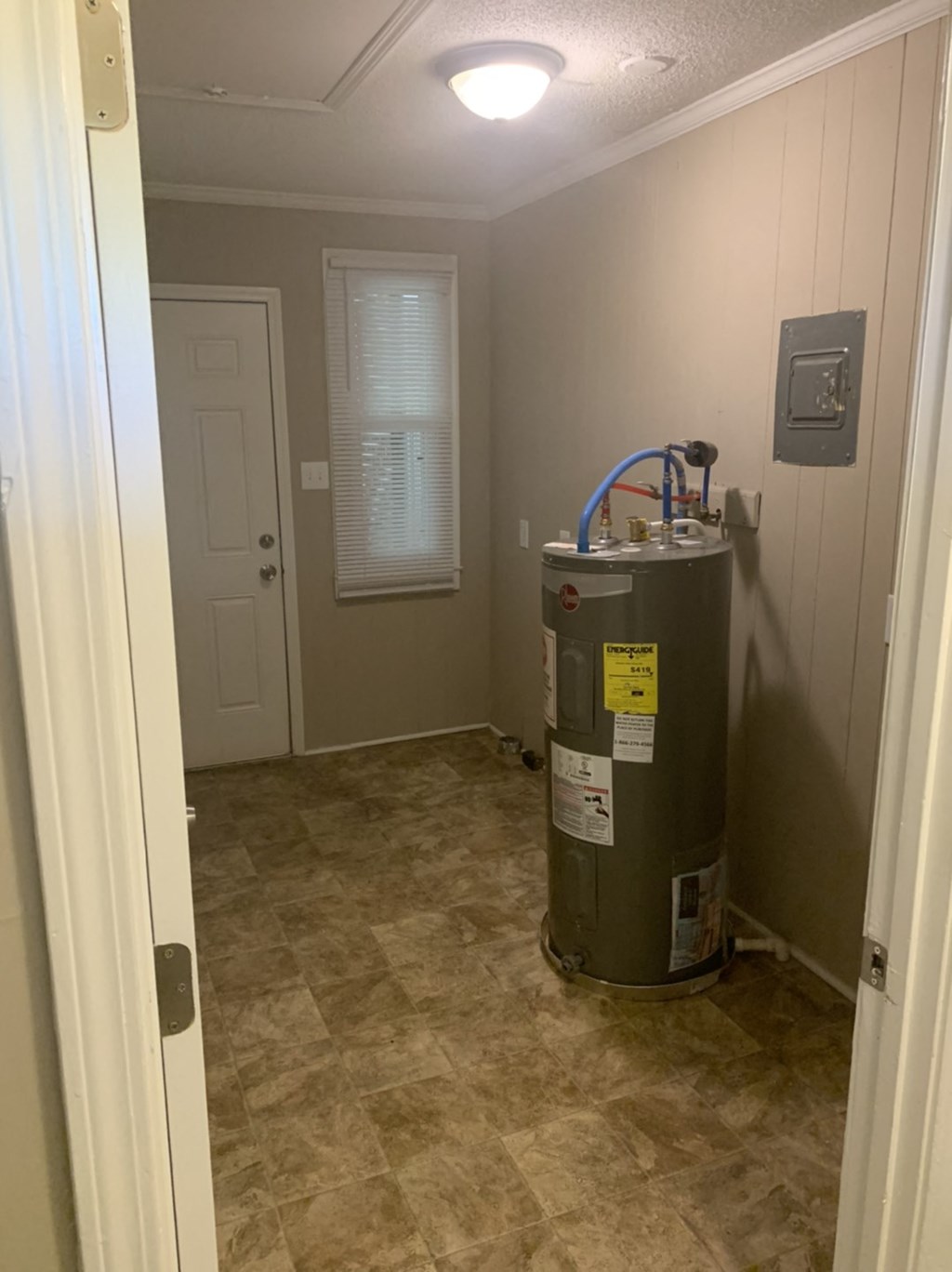 a room with a water heater and a door