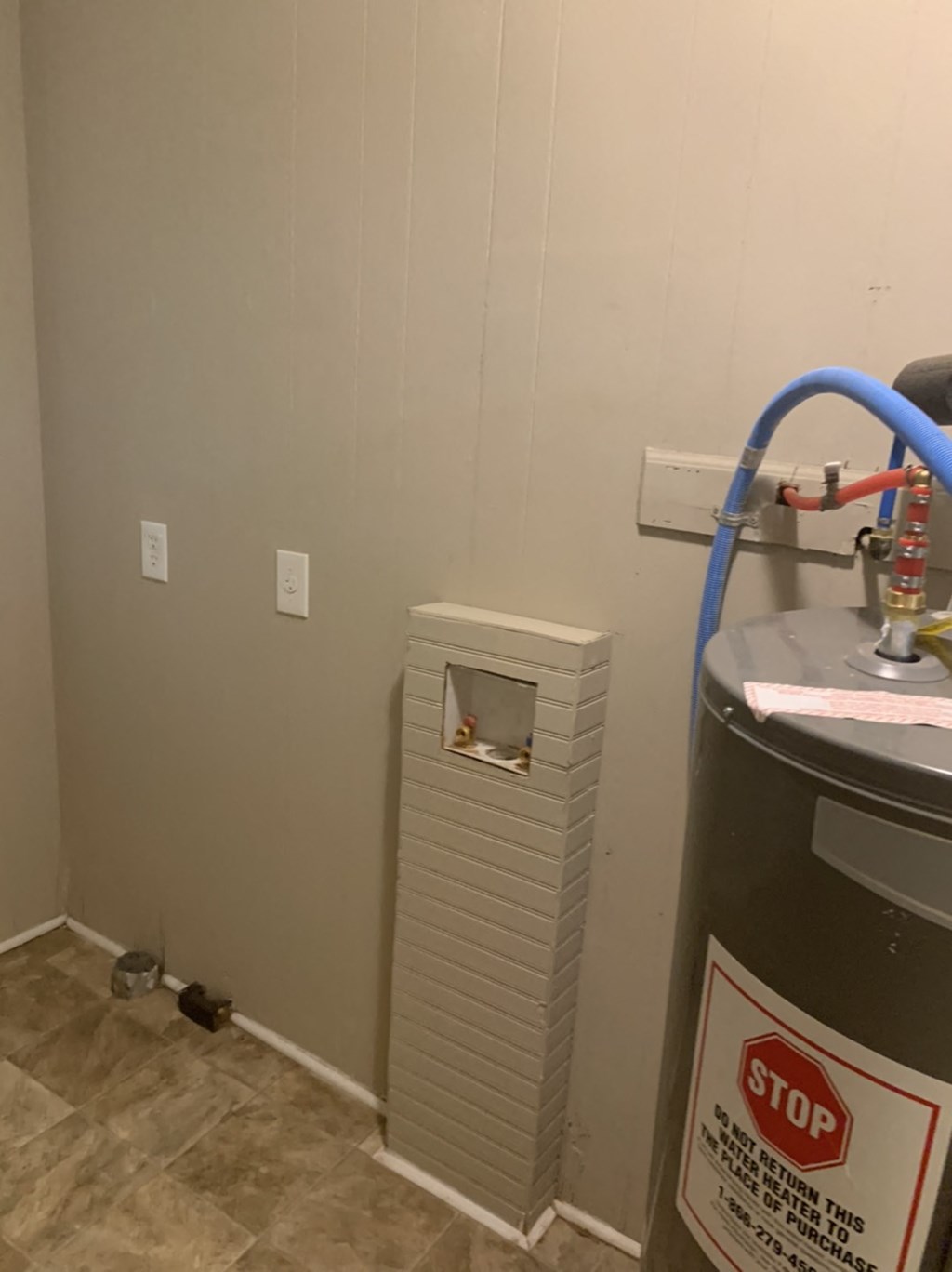 the corner of a room with a water heater and a stop sign