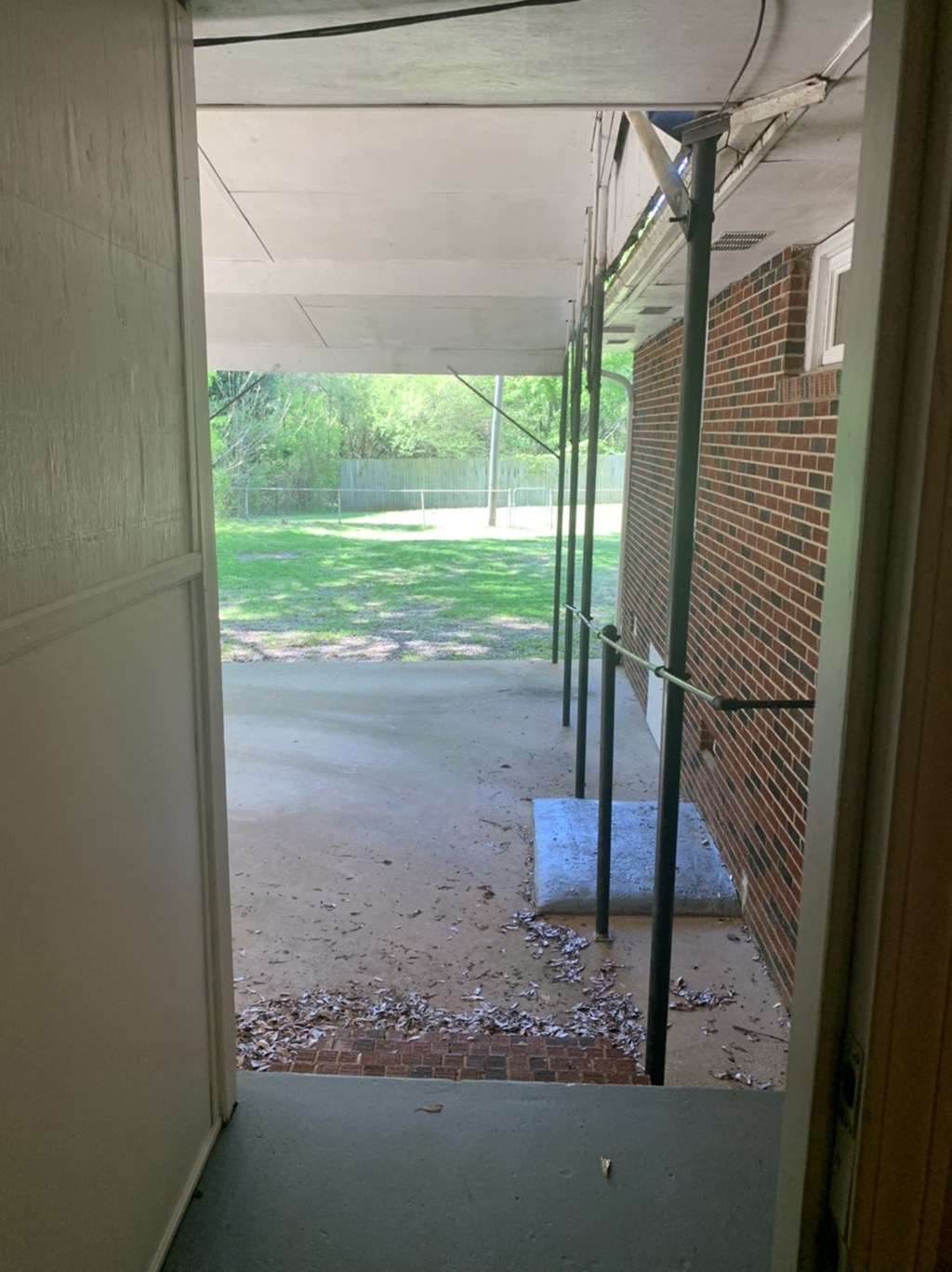a view of a porch from a door of a brick building