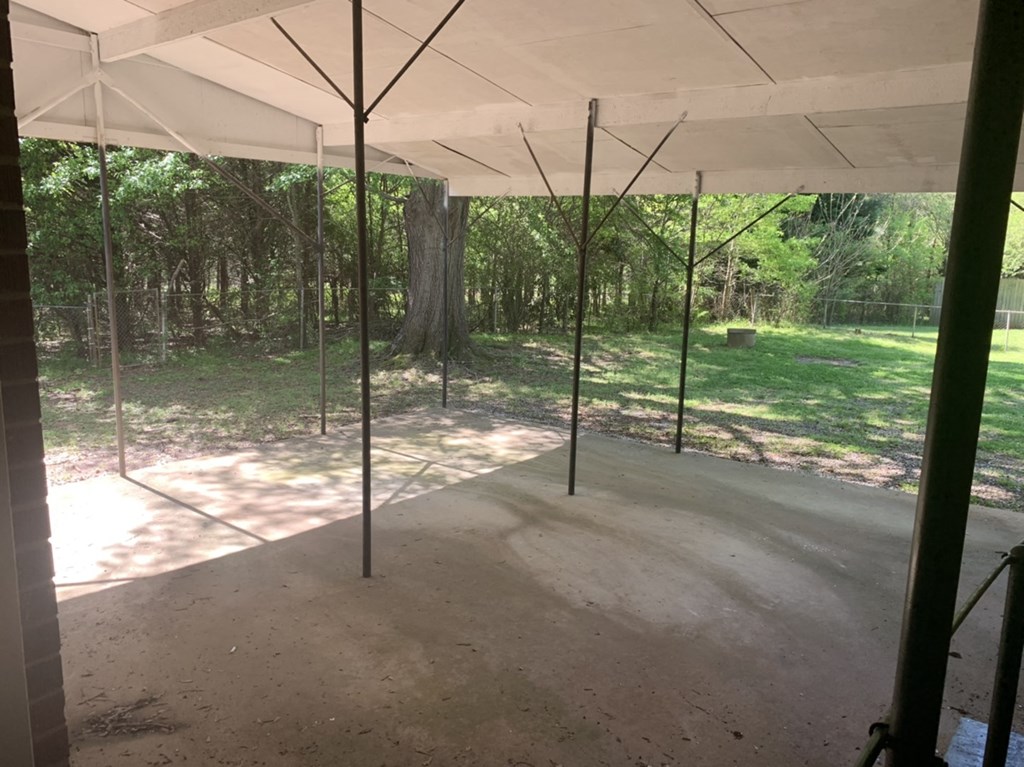 a room under a white canopy with trees in the background