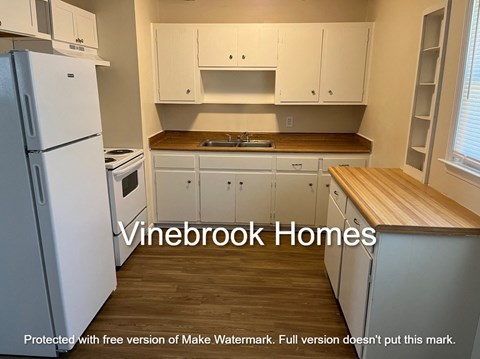 A kitchen with white appliances and cabinets.