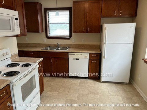 a kitchen with white appliances and wooden cabinets