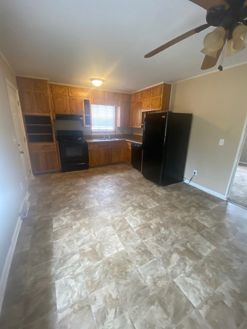 A kitchen with tile flooring and a ceiling fan.