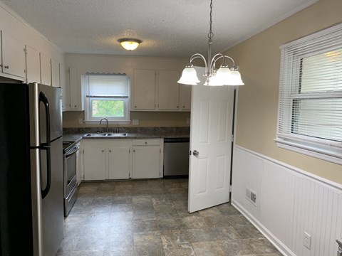a kitchen with white cabinets and stainless steel appliances