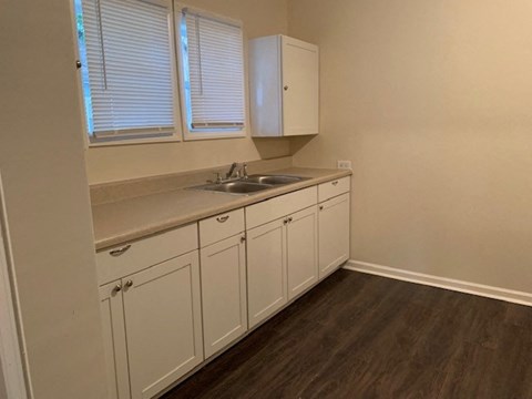 a small kitchen with a sink and white cabinets