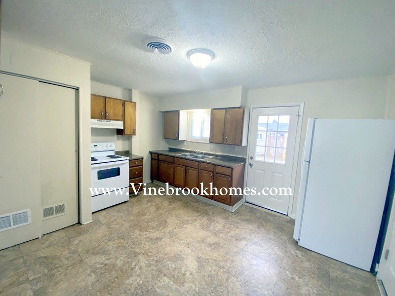 a kitchen with white appliances and wooden cabinets