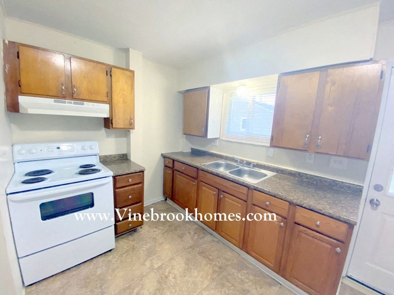 a kitchen with white appliances and wooden cabinets and a white stove