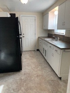 a kitchen with a black refrigerator and a sink