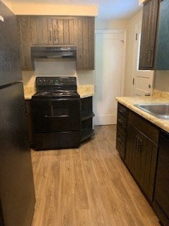 A black stove and oven in a kitchen with wooden floors.